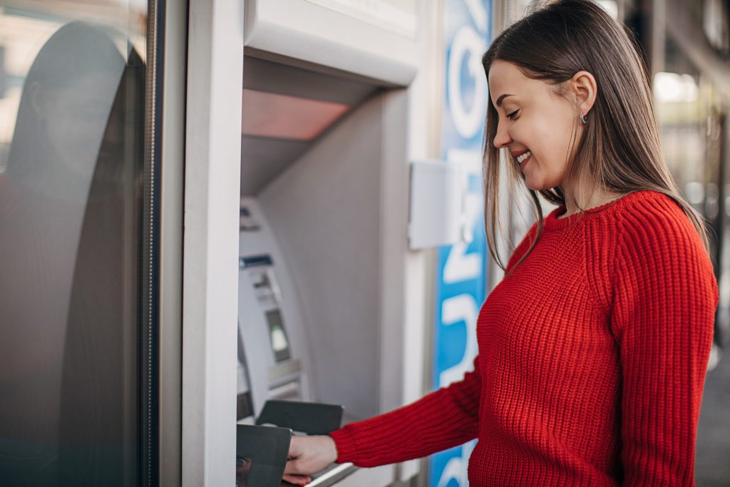Beautiful woman using ATM machine on the street