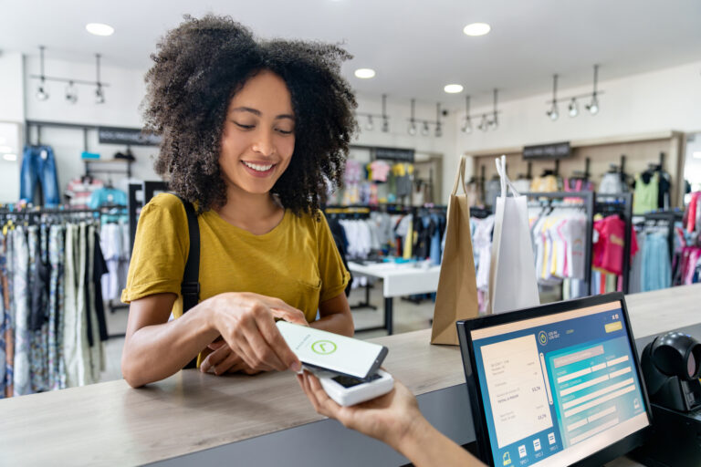 Woman making a mobile payment at a clothing store