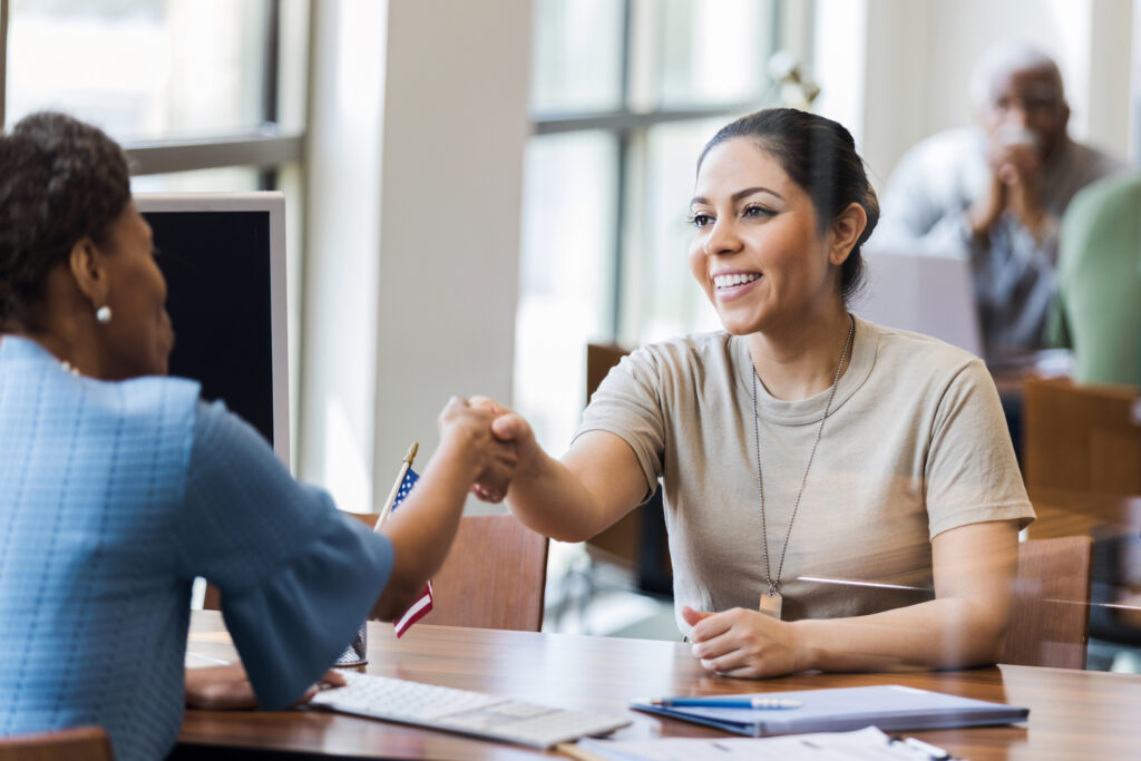 Mid Adult female soldier shakes hands with banker